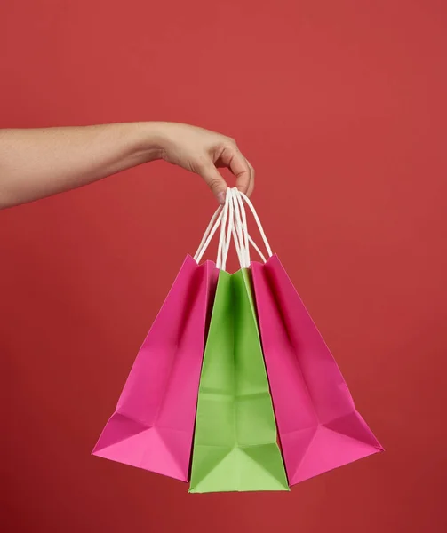 Mujer Sostiene Pila Bolsas Papel Sobre Fondo Rojo Concepto Compras — Foto de Stock