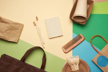 Yeşil zemin üzerinde kahverengi el işi kağıdından tek kullanımlık kağıt kaplar ve geri dönüşümlü malzemeler, plastik reddetme konsepti, sıfır atık, düz yatış