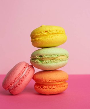 Pembe arka planda pişmiş makaron yığını, badem unundan yapılan lezzetli tatlı, yakın plan.