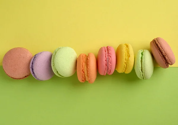 Baked Multi Colored Macaroon Cookies Lie Row Yellow Green Background — Stock Photo, Image