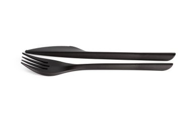 Tek kullanımlık siyah plastik çatal ve bıçak beyaz arka planda izole edilmiş.