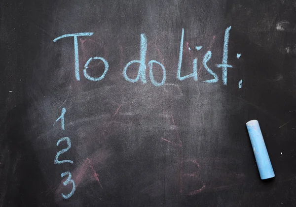 inscription to do list on a black chalk board and blue chalk, the concept of future planning, strategy