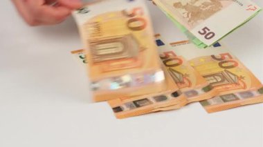 Kadın euro banknotlarını sayıyor, 150.000 doları beyaz bir masaya yatırıyor, kapatıyorlar.