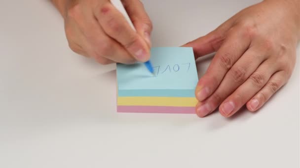 Weibliche Hand Schreibt Mit Stift Wörter Auf Bunte Papieraufkleber Nahaufnahme — Stockvideo