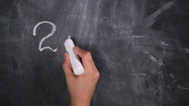 Siyah tebeşirle beyaz tebeşirle yazılmış matematik örneği ve beyaz tebeşirli bir kadın eli, iki artı iki.