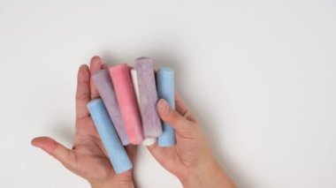 Kadın elleri tebeşir renginde, beyaz arkaplan, yukarıdan görünüm