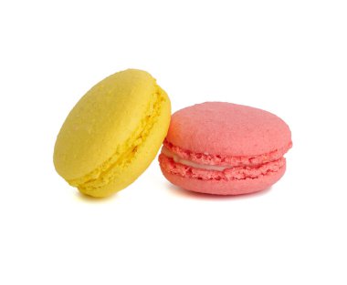 Beyaz arka planda izole edilmiş sarı ve pembe makaronlar, yakın plan.