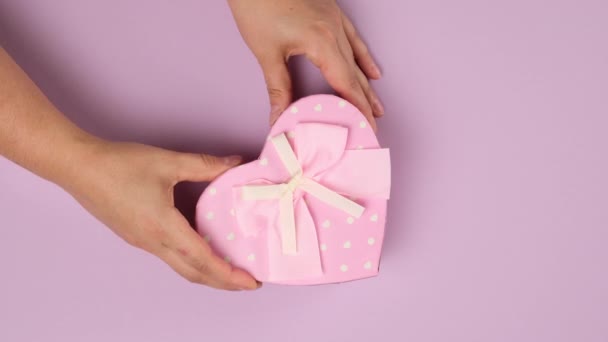 Two Female Hands Put Lilac Background Pink Cardboard Gift Box — Stock Video