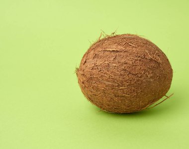 yeşil bir arka planda tüm yuvarlak hindistan cevizi, yakın yakın.