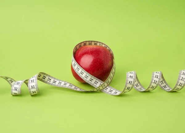 Manzana Roja Madura Envuelta Con Centímetro Sobre Fondo Verde Concepto — Foto de Stock