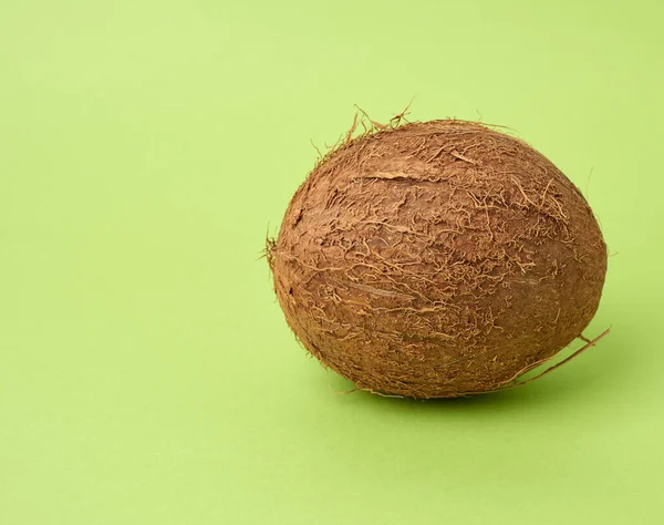 yeşil bir arka planda tüm yuvarlak hindistan cevizi, yakın yakın.