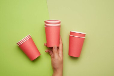 Yeşil zemin üzerinde kırmızı kağıt bardaklar yığını, konsept çevre dostu, sıfır atık 