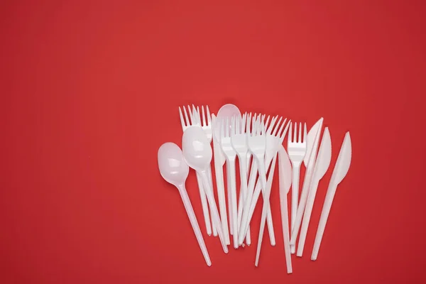 Stack Plastic Forks Spoons Red Background Top View Copy Space — Stock Photo, Image