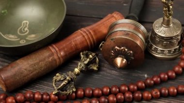 Kahverengi ahşap masa üzerinde ahşap bir çırpıcıyla Tibet 'te şarkı söyleyen bakır kâse meditasyon ve alternatif tıp aletleri.