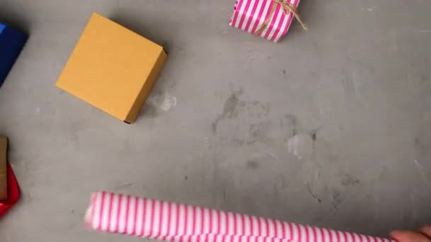 グレーのテーブルにピンクの紙に茶色の四角形の箱を詰め女性 フルーツパッキングプロセス トップビュー — ストック動画