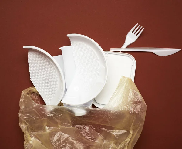Used Plastic Dishes Pieces Plastic White Plastic Bag Brown Background — Stock Photo, Image