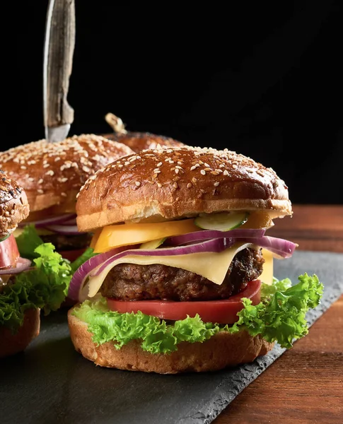 Lezzetli hamburgerler, kızarmış sığır pirzolası, domates, marul ve soğan, susamlı beyaz buğday unlu çörek. Fast food 