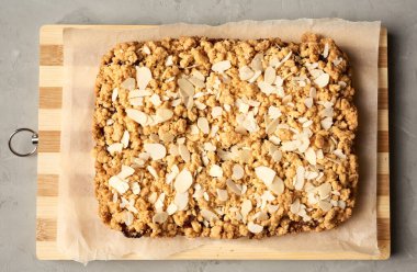 Ahşap tahtada meyveli fırınlanmış dikdörtgen pasta, gri arka plan, üst manzara.