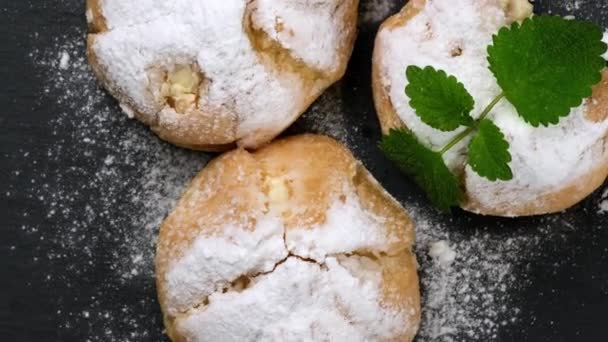 Péksütemény Eclair Porcukorral Megszórva Mentalevéllel Díszítve Egy Fekete Táblán Közelről — Stock videók