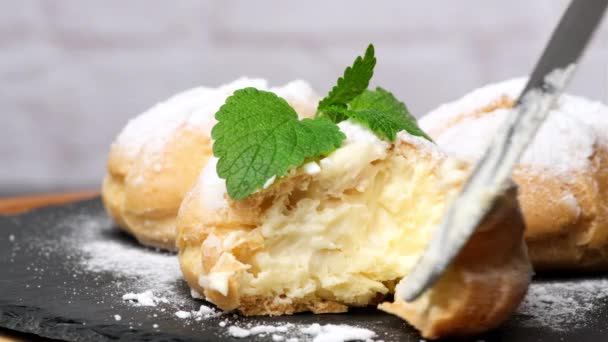 Kremalı Pasta Üzerine Pudra Şekeri Serpiştirilmiş Siyah Tahtada Bir Nane — Stok video
