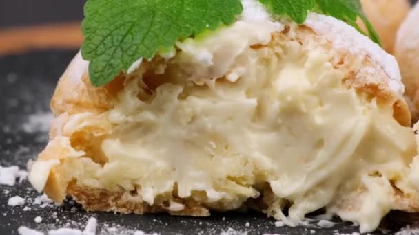 Kremalı Pasta Üzerine Pudra Şekeri Serpiştirilmiş Siyah Tahtada Bir Nane — Stok video