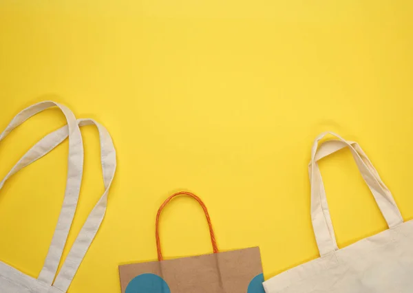 纸袋和黄色底色的空米色纺织品袋 拒收塑料袋 零废物 — 图库照片