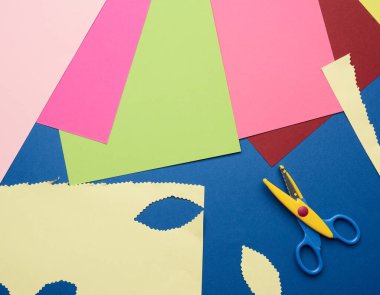 çok renkli kağıt ve plastik makas mavi zemin üzerinde, üst görünüm