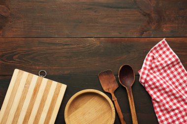boş ahşap kesme tahtası, ahşap yuvarlak tabak ve kaşıklar masanın üstünde, üst manzara, boşluğu kopyala