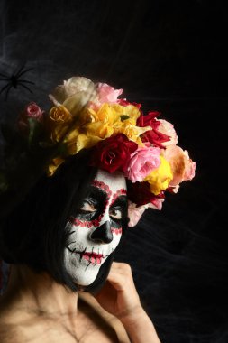 Kafkas görünümlü kadın çok renkli bir gül çelengi giyer. Şeker Kafatası Cadılar Bayramı Makyajı, Calavera Catrina