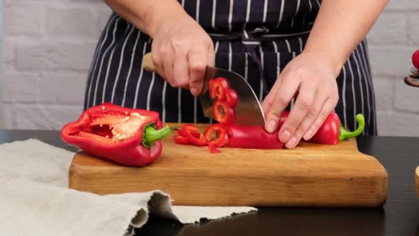 Caucasian Woman Blue Apron Cuts Ripe Red Bell Pepper Pieces — Stock Video