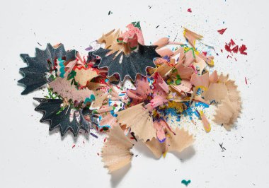 Çok renkli kalem talaşları ve beyaz arka plandaki rastgele bir yığın içinde yatan küçük talaş. Üst görünüm