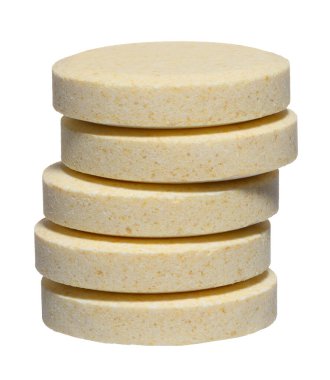 Büyük yuvarlak hapların dikey yığını açık sarı renkli, izole arkaplan