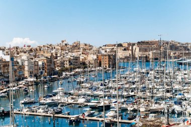 Birgu, Malta - 11 Nisan 2025: Limanın panoramik manzarası, demirli yatlar, Birgu (Vittoriosa) ve Senglea (Isla) arasındaki geleneksel kireçtaşı binalar)