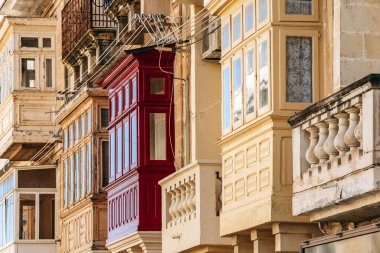 Geleneksel Malta ahşap balkonları kireçtaşı cephelerine canlı renklerle boyanmış, tipik tarihi şehir merkezi mimarisi..