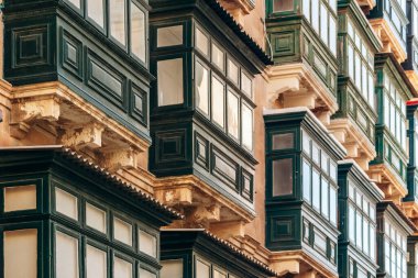 Geleneksel Malta ahşap balkonları kireçtaşı cephelerine canlı renklerle boyanmış, tipik tarihi şehir merkezi mimarisi..