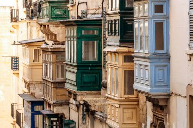 Geleneksel Malta ahşap balkonları kireçtaşı cephelerine canlı renklerle boyanmış, tipik tarihi şehir merkezi mimarisi..