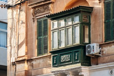 Geleneksel Malta ahşap balkonları kireçtaşı cephelerine canlı renklerle boyanmış, tipik tarihi şehir merkezi mimarisi..
