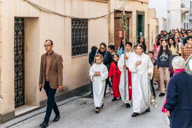 Sliema, Malta - 14 Nisan 2025: Dar Malta sokaklarında yürüyen çocuklar ve yetişkinlerle Kutsal Hafta 'nın başlangıcını simgeleyen dini sokak geçidi