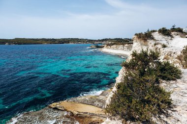 Beyaz kireçtaşı kayalıkları ve parlak turkuaz Akdeniz suları Marsaskala ve Marsaxlokk, Malta arasında kıyı şeridi boyunca