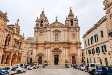 Mdina, Malta - 14 Nisan 2025: Görkemli St. Paul Katedrali Mdina 'nın merkez meydanına hükmediyor, barok cephesini ikiz çan kuleleri, yontulmuş detaylar ve simetrik zarafetiyle sergiliyor.