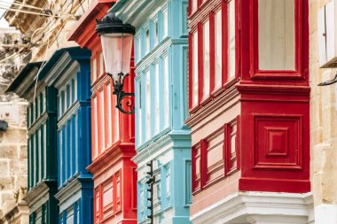 Geleneksel Malta ahşap balkonları kireçtaşı cephelerine canlı renklerle boyanmış, tipik tarihi şehir merkezi mimarisi..