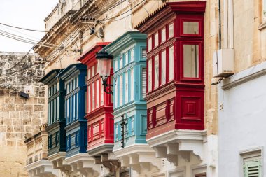 Geleneksel Malta ahşap balkonları kireçtaşı cephelerine canlı renklerle boyanmış, tipik tarihi şehir merkezi mimarisi..