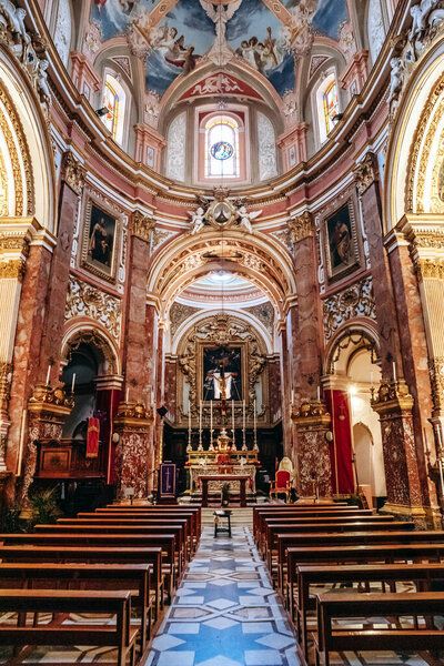 Мдина, Мальта - 14 апреля 2024 года: Интерьер церкви кармелитов в стиле барокко в Мдине, Мальта, с богато украшенным алтарем, фресковым куполом и мраморными колоннами.