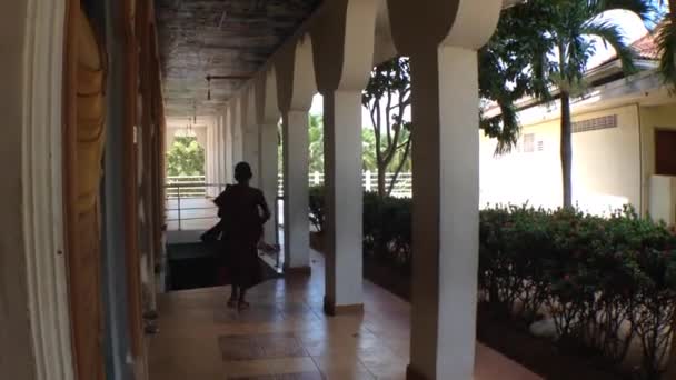 Маленький мальчик-монах бежит в храм — стоковое видео
