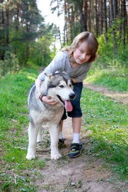 Çocuk onun köpek malamute ormanda bir yürüyüş ile