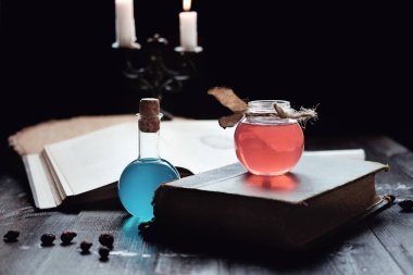 Magic and wizardry concept. Set of sorcery book, magic potions and candles on table. Health and mana potion. Alchemy concept. clipart