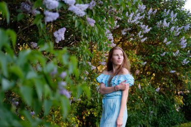 Kızıl saçlı kız mavi ışık kokteyl elbise Lila çalıların arasında 