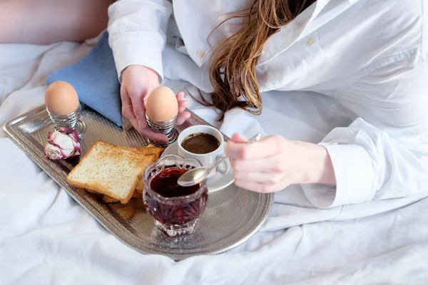 Breakfast in bed in hotel. Redhead gird after taking shower has a breakfast in bed in hotel room.