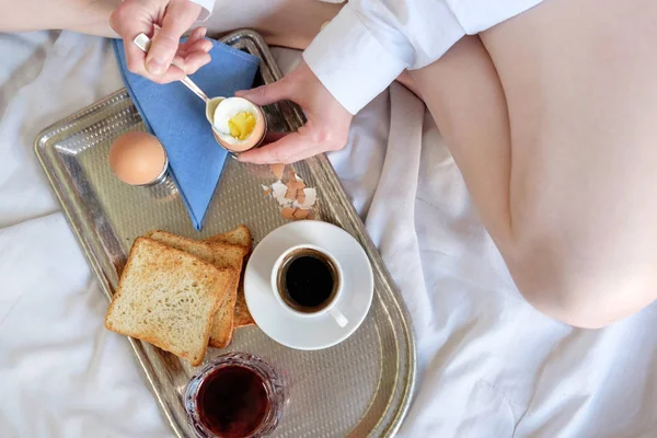 Breakfast in bed in hotel. Redhead gird after taking shower has a breakfast in bed in hotel room.