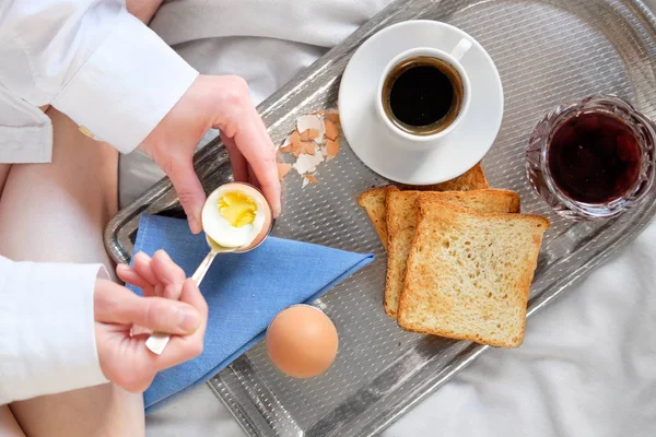 Breakfast in bed in hotel. Redhead gird after taking shower has a breakfast in bed in hotel room.